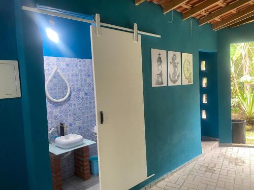 a bathroom with a toilet and a blue wall at Casa com 2 Piscinas infantil e adulto a 450m da Praia Até 15 Pessoas in São Sebastião