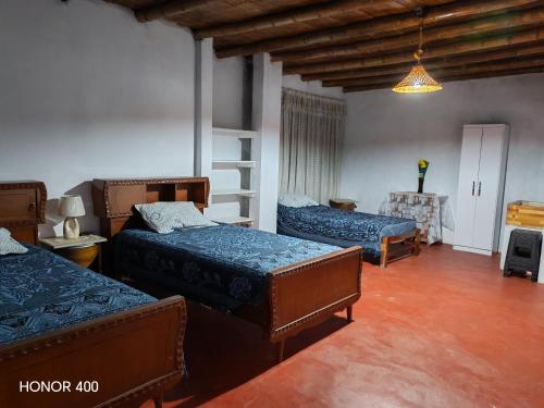 a bedroom with two beds and a room with a table at Casita de camucha segundo piso in Chincha Baja