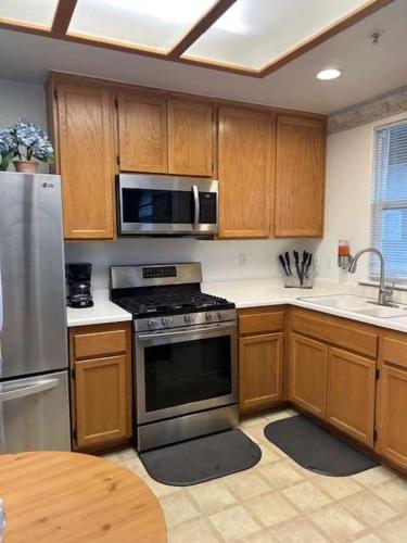 a kitchen with wooden cabinets and a stainless steel appliance at Low Tide Lounge in Oceano