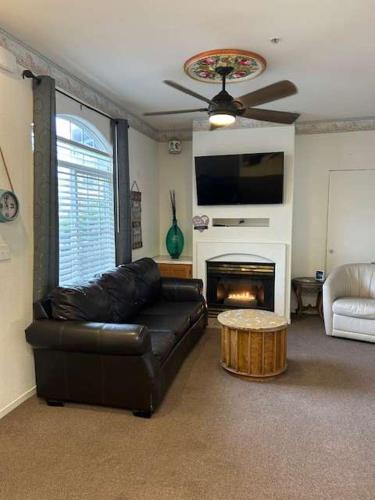 a living room with a leather couch and a fireplace at Low Tide Lounge in Oceano
