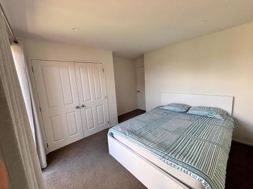 a bedroom with a bed and a white door at Dream House 5 in Auckland