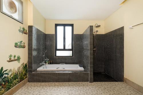 a bathroom with a tub and a window at Rawai - 3 BR Private Pool Villa - Phoomjai Villa in Rawai Beach