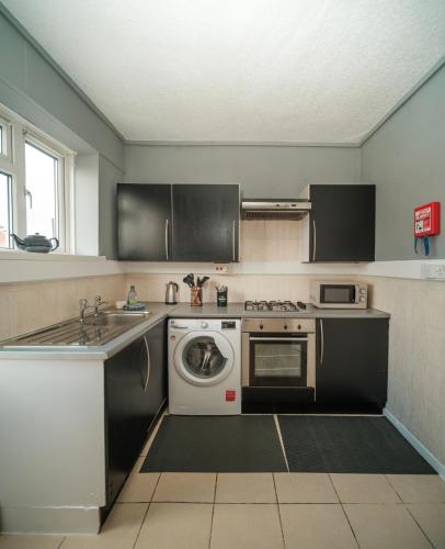 a kitchen with a washing machine and a dishwasher at 5 of 5 Room Cozy, spacious and modern in Camden Town in London