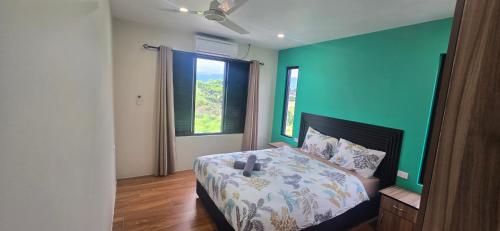a bedroom with a bed and a green wall at The Retreat Apartment in Nadi