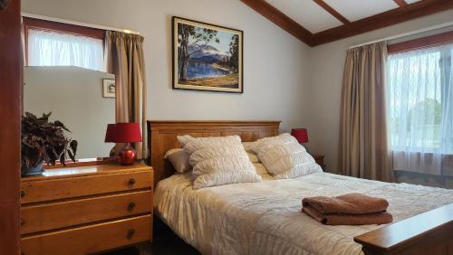 a bedroom with a bed and a dresser and a window at La Casa in Napier
