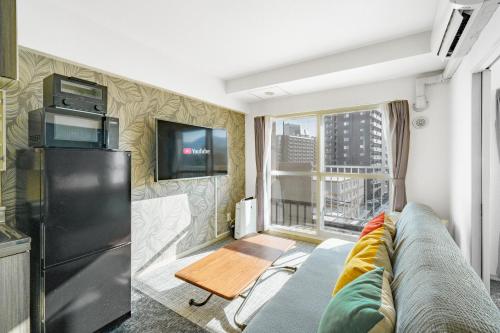 a living room with a couch and a tv at 88 Matsui Building Sapporo in Sapporo