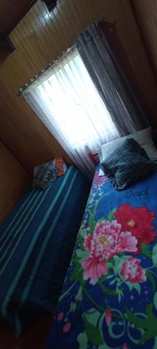 a bedroom with two twin beds with a window at Cabaña Quiroz in Valdivia