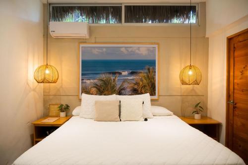 a bedroom with a bed with a view of the ocean at Hotel Michanti in El Zonte