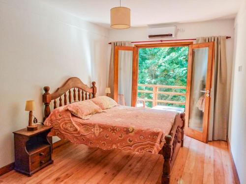 a bedroom with a bed and a large window at Casa Cabaña Los Zorzales Santa Clara del Mar-Argentina in Santa Clara del Mar