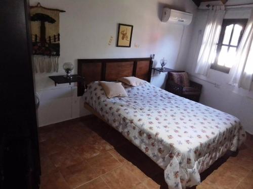 a bedroom with a bed and a chair at Claro de Luna in Los Reartes