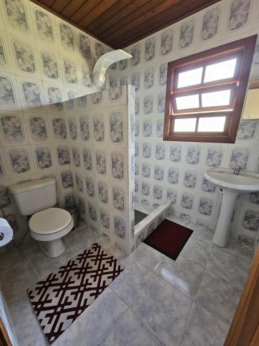 a bathroom with a toilet and a sink at Chalé Canário da Terra 2 in Visconde De Maua