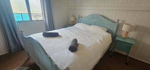 a bedroom with a blue bed with a blue headboard at Main St Heritage Charm & Walk to Restaurants in Mount Tamborine