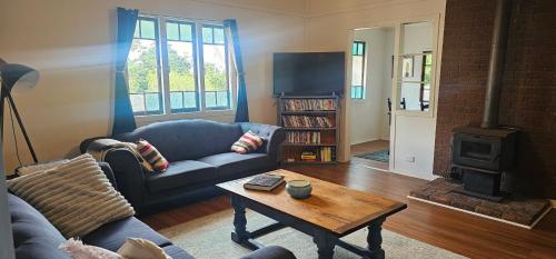 a living room with a couch and a coffee table at Main St Heritage Charm & Walk to Restaurants in Mount Tamborine
