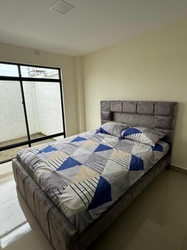 a bed in a bedroom with a large window at Confortable casa independiente in Crucita