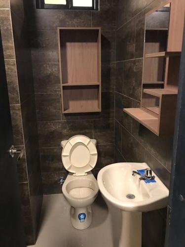 a bathroom with a toilet and a sink at Confortable casa independiente in Crucita