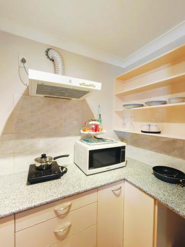 a kitchen with a microwave on a counter at Bayview Holiday Flat in Auckland