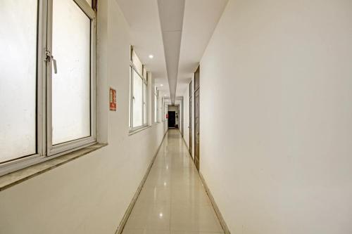 an empty hallway with white walls and windows at Super Hotel O Glorious Stayz in Noida