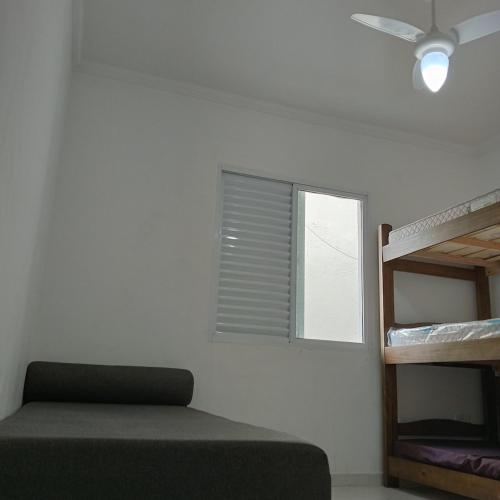 a bedroom with a bunk bed and a window at Enseada Perto da praia Guarujá com vaga de garagem in Guarujá