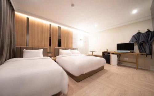 a hotel room with two beds and a television at Hotel Label Seongnam in Seongnam