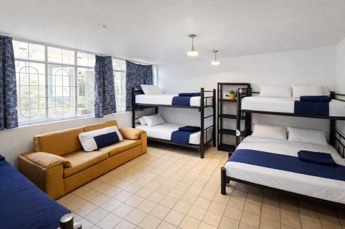a room with four bunk beds and a couch at Free Spirit Experience Guadalajara Centro in Guadalajara