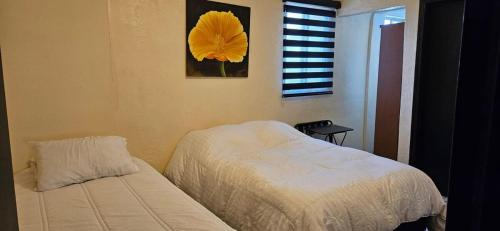 a bedroom with a bed and a yellow flower on the wall at Departamento Ruze Privado-Tranquilo in Plan Libertador