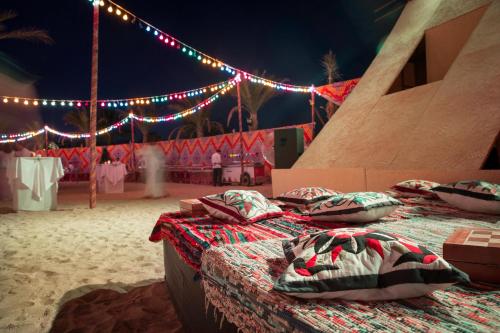 two beds in front of a tent with lights at Robinson Soma Bay in Hurghada