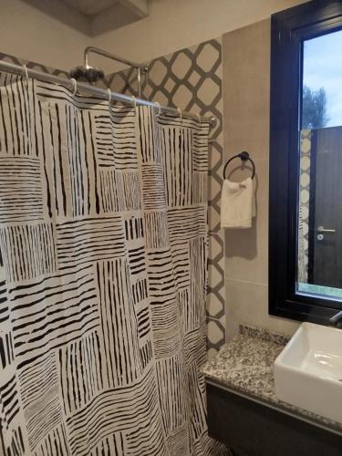 a bathroom with a shower curtain and a sink at Casa a estrenar En Trapiche - Pileta privada in Trapiche