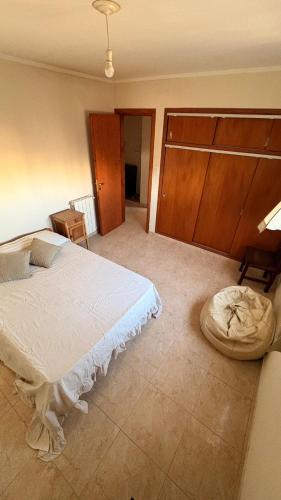 a bedroom with a white bed and a wooden wall at Malvinas Casa de Playa in Necochea