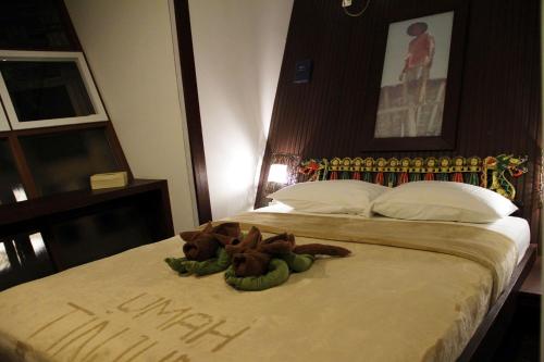 a stuffed animal is laying on a bed at Bali Umah Tinjung in Tulamben
