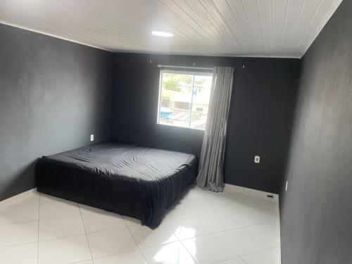 a small bedroom with a bed and a window at Lareaconchego in São Pedro da Aldeia