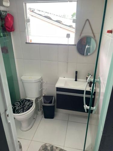 a bathroom with a toilet and a sink and a mirror at Lareaconchego in São Pedro da Aldeia