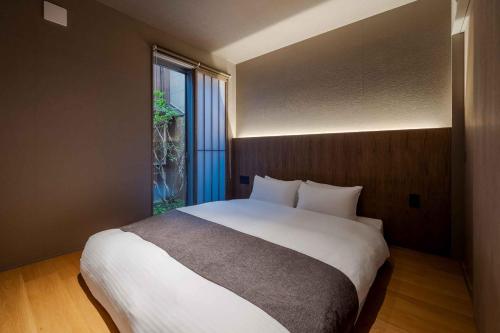 a bedroom with a large bed and a window at Itose Machiya House in Kanazawa