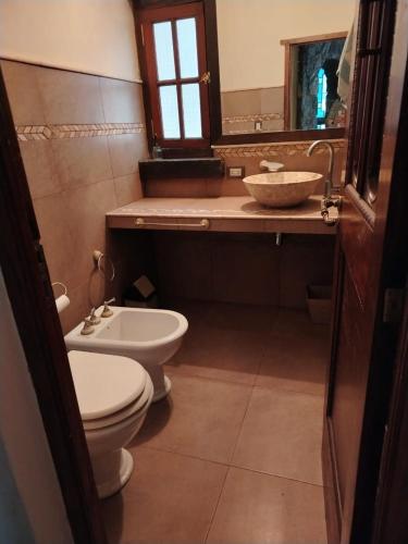 a bathroom with a toilet and a sink and a mirror at Lagriega in Cuesta Blanca