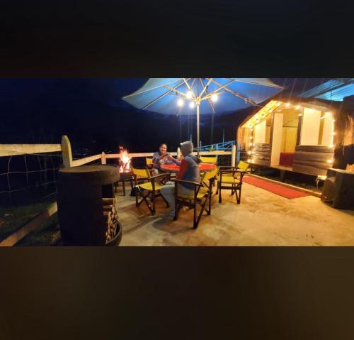 a group of people sitting at a table on a patio at night at Finca Agrópolis de Silvania in Silvania