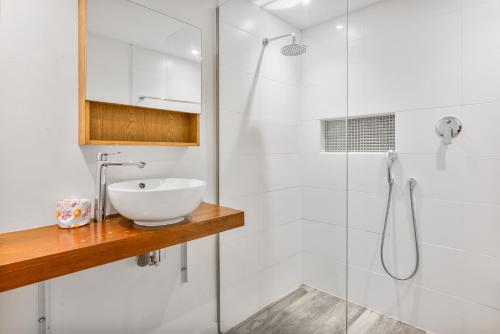 a white bathroom with a sink and a shower at INDIGO Apartments & Suites - 'Adults Only' in Jan Thiel