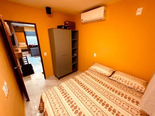 a bedroom with a bed and a yellow wall at CASA CONTAINER Vsa in Vitória de Santo Antão