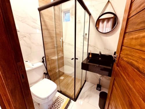 a bathroom with a toilet and a glass shower at CASA CONTAINER Vsa in Vitória de Santo Antão
