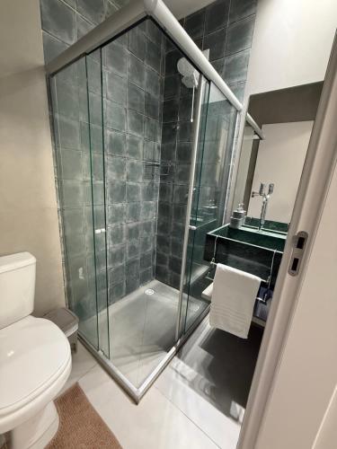 a bathroom with a shower with a toilet and a sink at Apartamento A03 - Curimã in Passo de Camarajibe