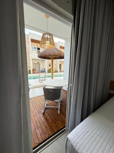a view of a bedroom with a table and umbrella at Apartamento A03 - Curimã in Passo de Camarajibe