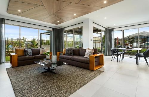 a living room with two couches and a table at Luxury 4BR Retreat with Pool & Private Spa Bath in Marsden Park