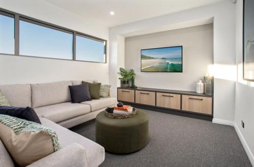 a living room with a couch and a tv at Luxury 4BR Retreat with Pool & Private Spa Bath in Marsden Park