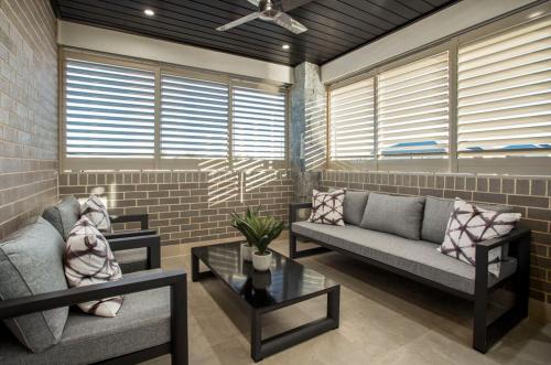 a living room with two couches and a table at Luxury 4BR Retreat with Pool & Private Spa Bath in Marsden Park