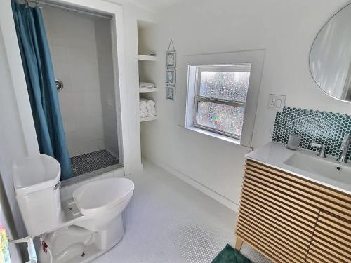 een badkamer met toilet, wastafel en raam bij St Augustine Island, King Bed, Beach Living in St. Augustine