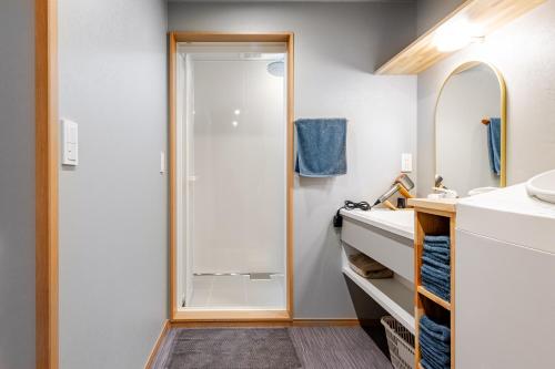 a bathroom with a shower and a sink at Fukuyado Sakurazaka in Fukuoka