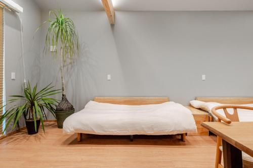 a bedroom with a bed and two potted plants at Fukuyado Sakurazaka in Fukuoka