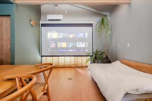 a living room with a large screen in a room at Fukuyado Sakurazaka in Fukuoka