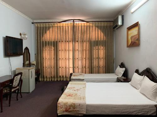 a hotel room with two beds and a television at Kim Anh Hotel in Hanoi