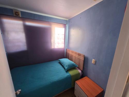 a small bedroom with a bed and a window at Casa Flor del aire in La Serena