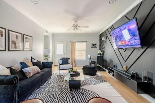 a living room with a couch and a flat screen tv at Fireside Double Kings Midtown Luxe Suite in Houston