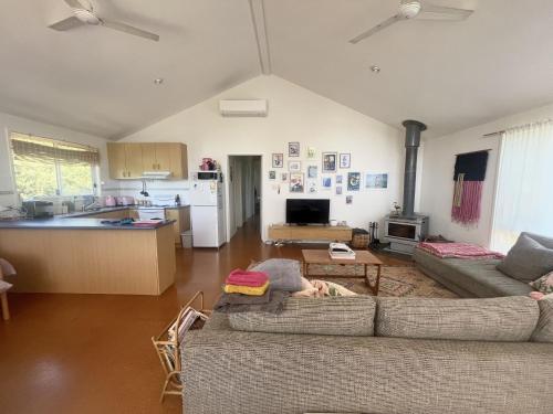 a living room with two couches and a kitchen at La Sirena, Venus Bay in Venus Bay